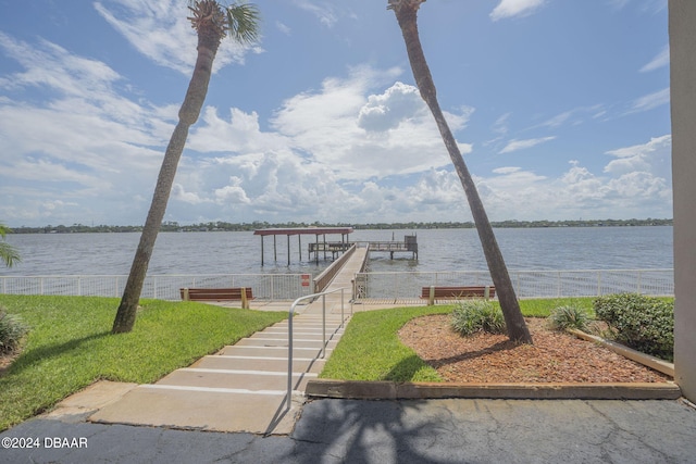 dock area with a lawn and a water view