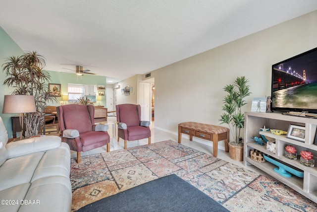 living room with ceiling fan and a textured ceiling