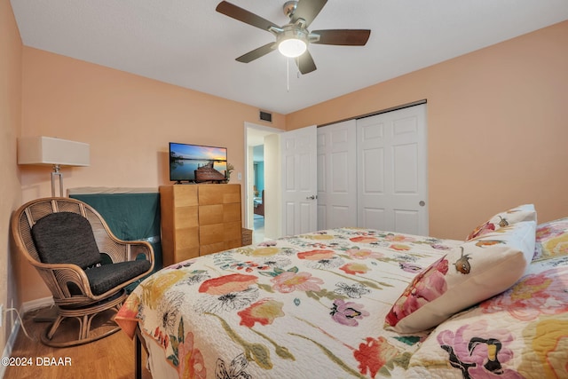 bedroom with ceiling fan, a closet, and hardwood / wood-style flooring