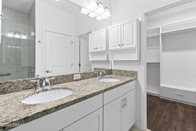 562 Landshark Blvd, Daytona Beach, FL 32124 - full bathroom featuring a shower stall, double vanity, a walk in closet, and wood finished floors