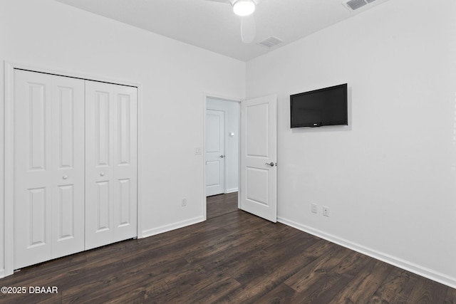 562 Landshark Blvd, Daytona Beach, FL 32124 - unfurnished bedroom with dark wood-type flooring, a closet, and ceiling fan