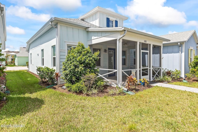 562 Landshark Blvd, Daytona Beach, FL 32124 - back of property with board and batten siding, a lawn, and roof with shingles