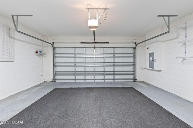 562 Landshark Blvd, Daytona Beach, FL 32124 - garage featuring a garage door opener, electric panel, and concrete block wall