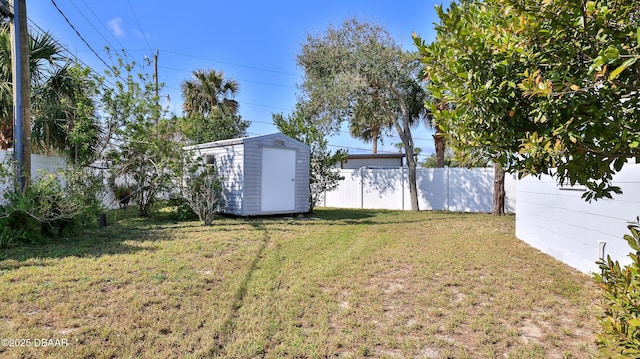 view of yard with an outbuilding, a storage shed, and a fenced backyard