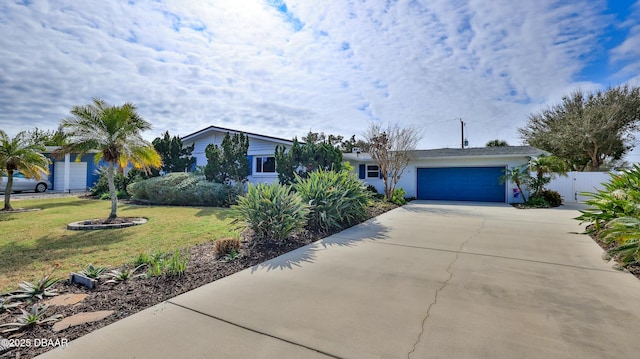 ranch-style house featuring a garage and a front lawn