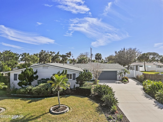 view of front of house featuring a garage, concrete driveway, a front lawn, and fence