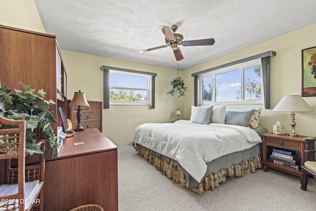 bedroom with light carpet and a ceiling fan