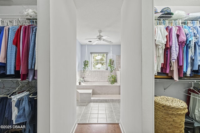 walk in closet with tile patterned flooring and a ceiling fan