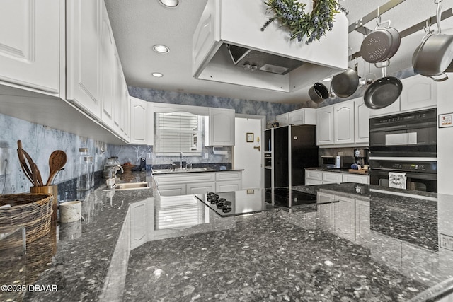 kitchen featuring black appliances, white cabinets, custom exhaust hood, and a sink