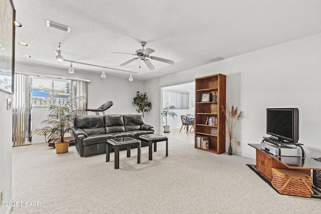 carpeted living room with visible vents, a textured ceiling, ceiling fan, and track lighting