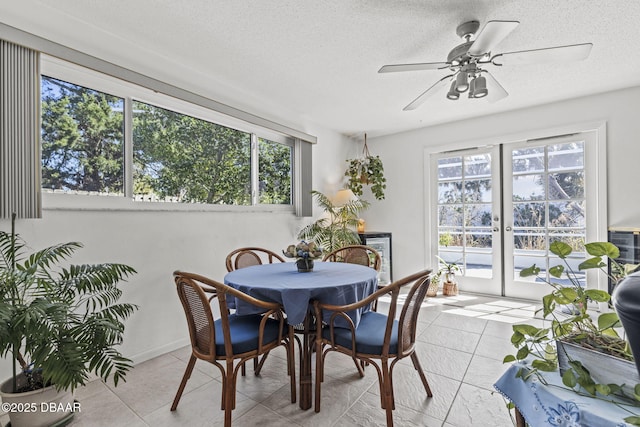 dining area with a wealth of natural light, french doors, a textured ceiling, and light tile patterned floors