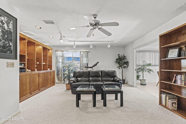 living area with rail lighting, carpet flooring, a ceiling fan, and a textured ceiling