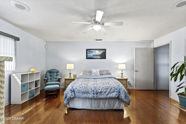 bedroom featuring visible vents, a textured ceiling, wood finished floors, and a ceiling fan