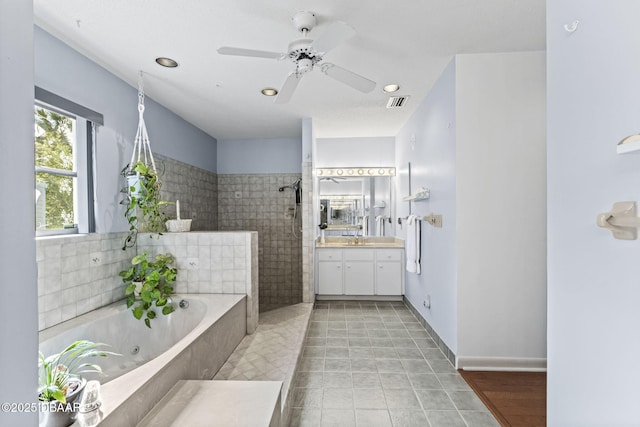 full bathroom featuring vanity, a tub with jets, visible vents, tile patterned flooring, and a walk in shower