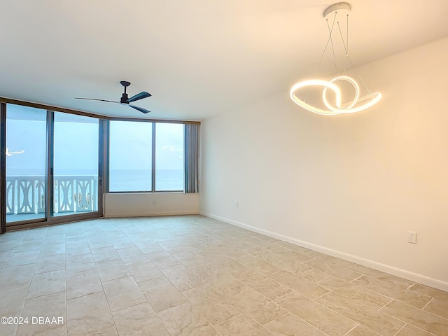 empty room with ceiling fan and floor to ceiling windows