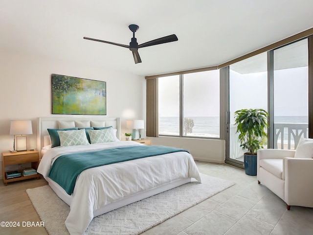 bedroom with a water view and ceiling fan