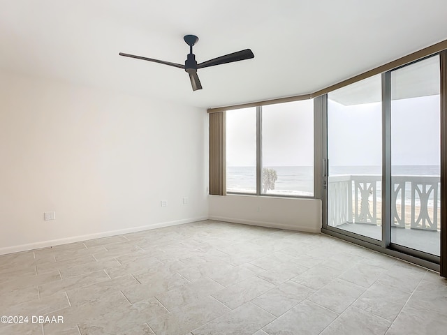 spare room with ceiling fan and a water view