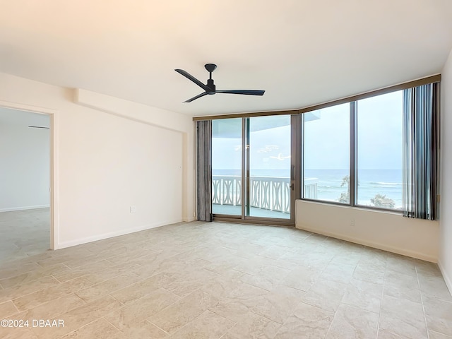 empty room featuring a water view and ceiling fan