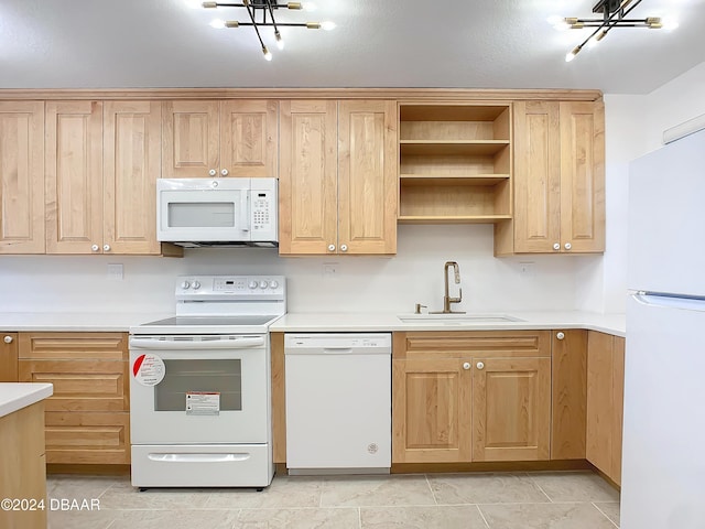 kitchen featuring light tile patterned floors, white appliances, a notable chandelier, and sink