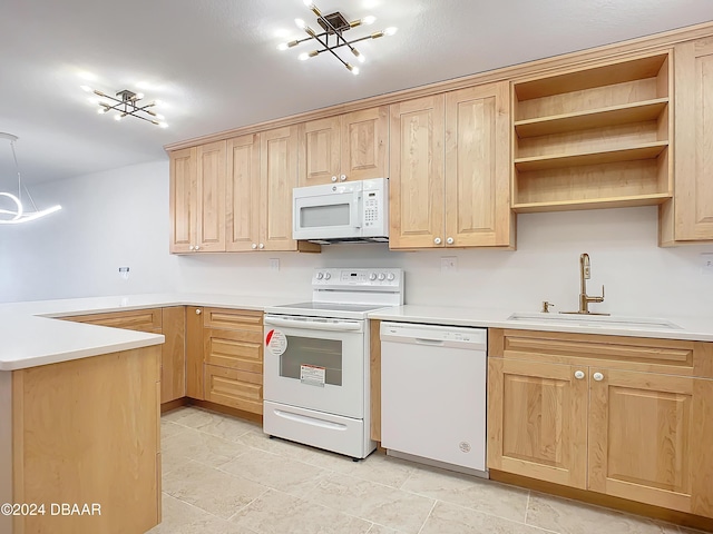 kitchen featuring kitchen peninsula, light brown cabinetry, white appliances, and sink