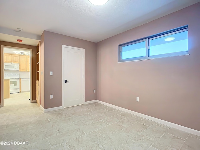 unfurnished room with a textured ceiling