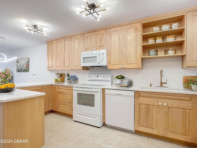 kitchen with light brown cabinets, white appliances, an inviting chandelier, sink, and kitchen peninsula