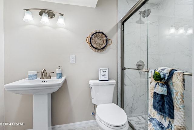 bathroom featuring toilet, an enclosed shower, and sink