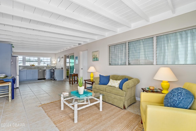 living room with beam ceiling and light tile patterned floors