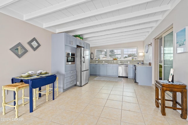 kitchen featuring lofted ceiling with beams, sink, light tile patterned floors, light stone counters, and stainless steel appliances