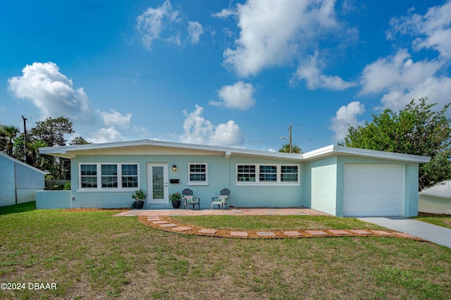 single story home featuring a patio, a garage, and a front lawn