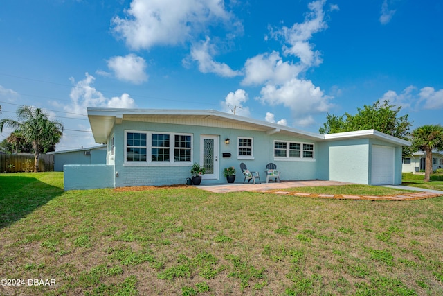 ranch-style house featuring a front yard and a patio