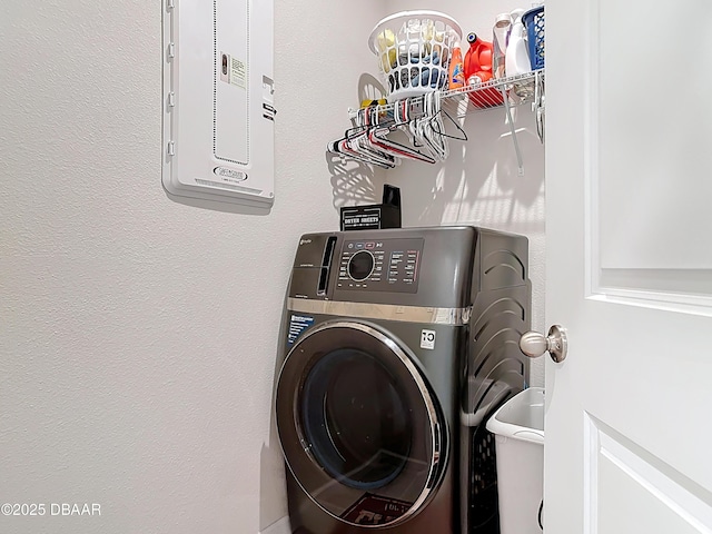 laundry room with laundry area, washer / clothes dryer, and a textured wall