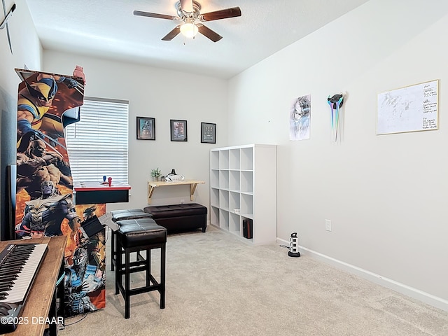 sitting room with baseboards, carpet, and a ceiling fan