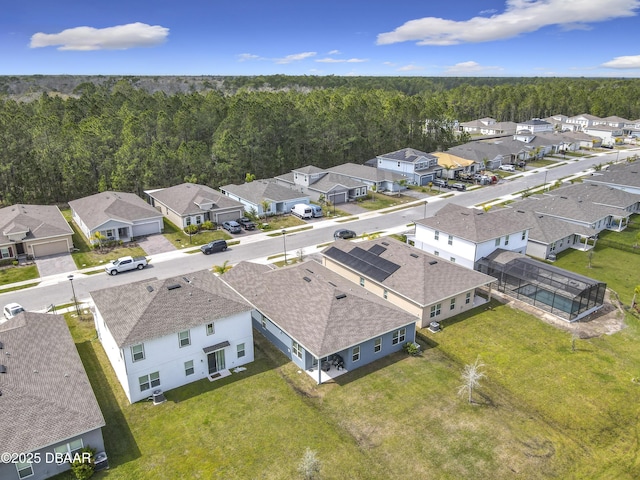 bird's eye view with a wooded view and a residential view