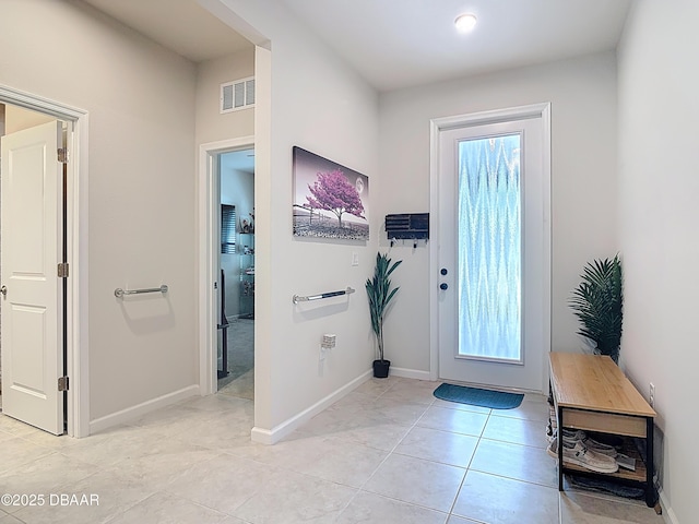 foyer entrance featuring visible vents, baseboards, and light tile patterned flooring