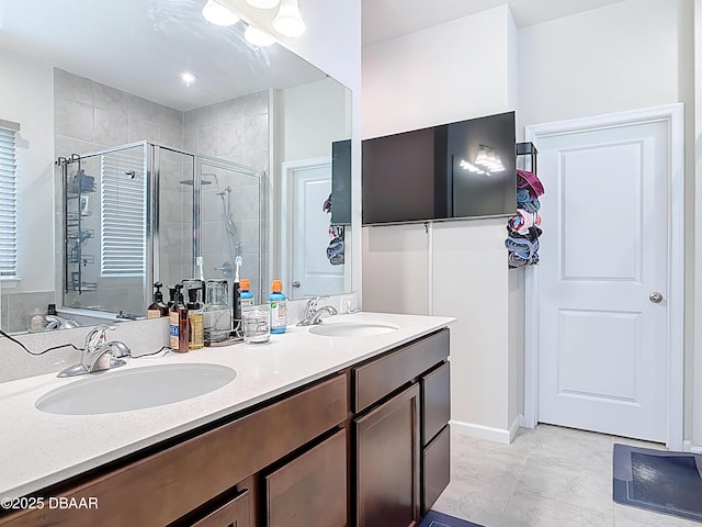 full bath with a sink, a stall shower, and double vanity