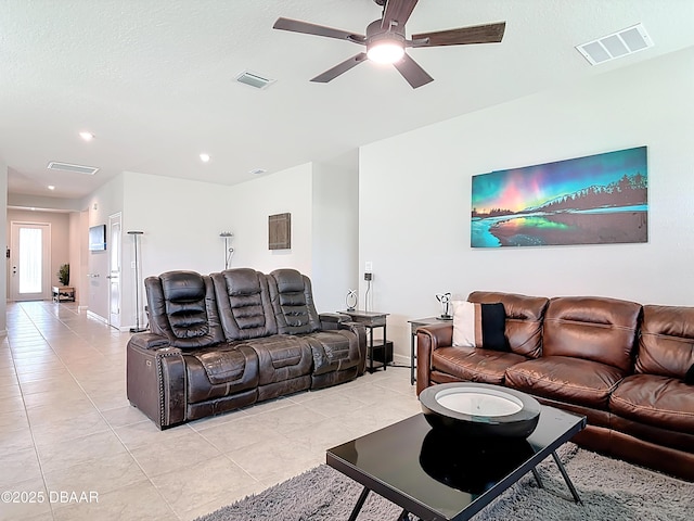 living area with light tile patterned floors, visible vents, and a ceiling fan