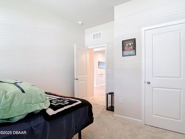 bedroom with light colored carpet, visible vents, and baseboards