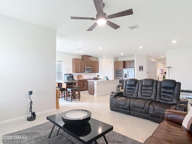 living room with light tile patterned floors, a ceiling fan, visible vents, baseboards, and recessed lighting