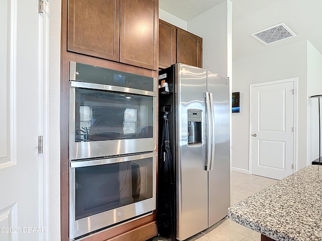 kitchen featuring light countertops, light tile patterned flooring, visible vents, and appliances with stainless steel finishes