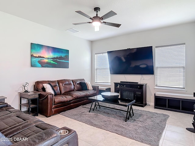 living room with tile patterned flooring, plenty of natural light, visible vents, and ceiling fan