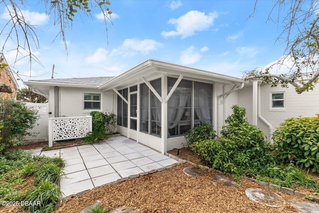 rear view of property featuring a patio and a sunroom