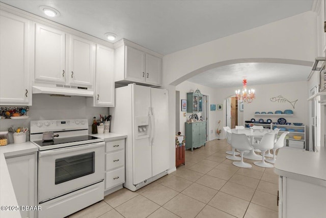 kitchen with white cabinets, light tile patterned floors, and white appliances