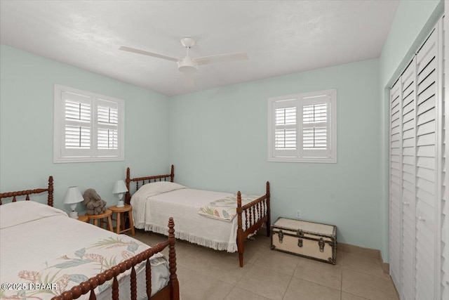 tiled bedroom featuring ceiling fan and a closet