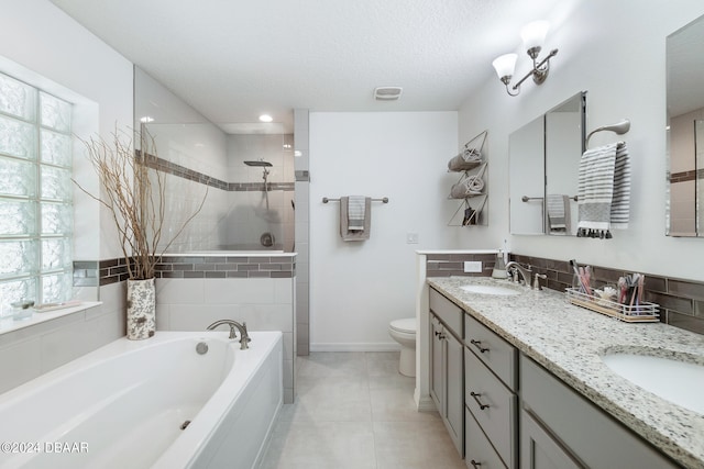 full bathroom with toilet, separate shower and tub, tile patterned flooring, a textured ceiling, and vanity