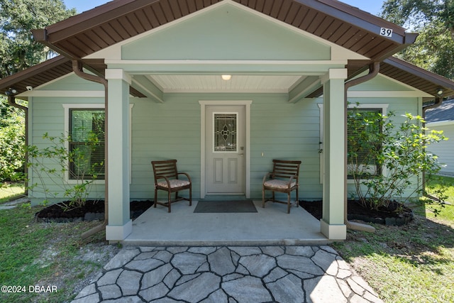 view of exterior entry featuring covered porch