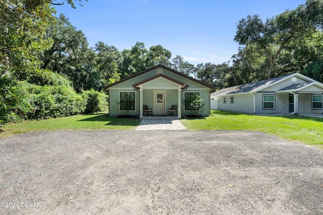 bungalow-style home with covered porch and a front yard