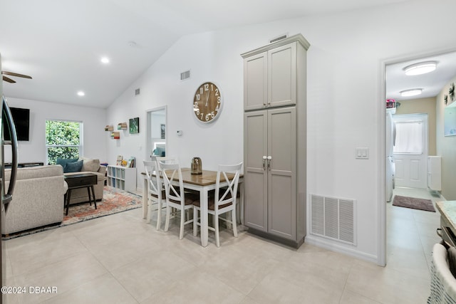 tiled dining space with ceiling fan and vaulted ceiling