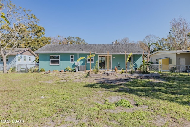 view of front of house with stucco siding, a gate, fence, and a front yard