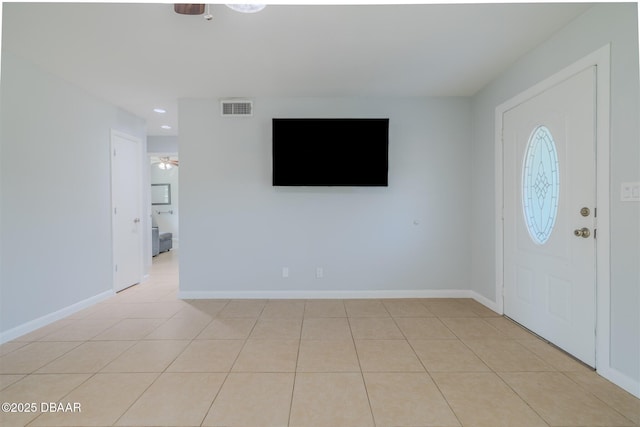 foyer entrance with visible vents, ceiling fan, baseboards, and light tile patterned floors